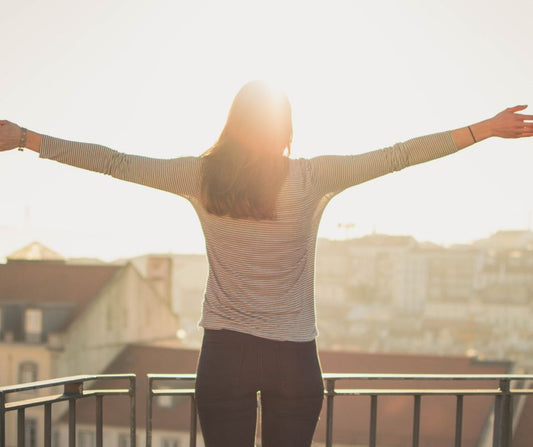 A person greeting the sunrise with open arms.