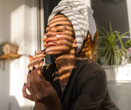 A woman enjoying the afternoon sun while applying moisturizer.