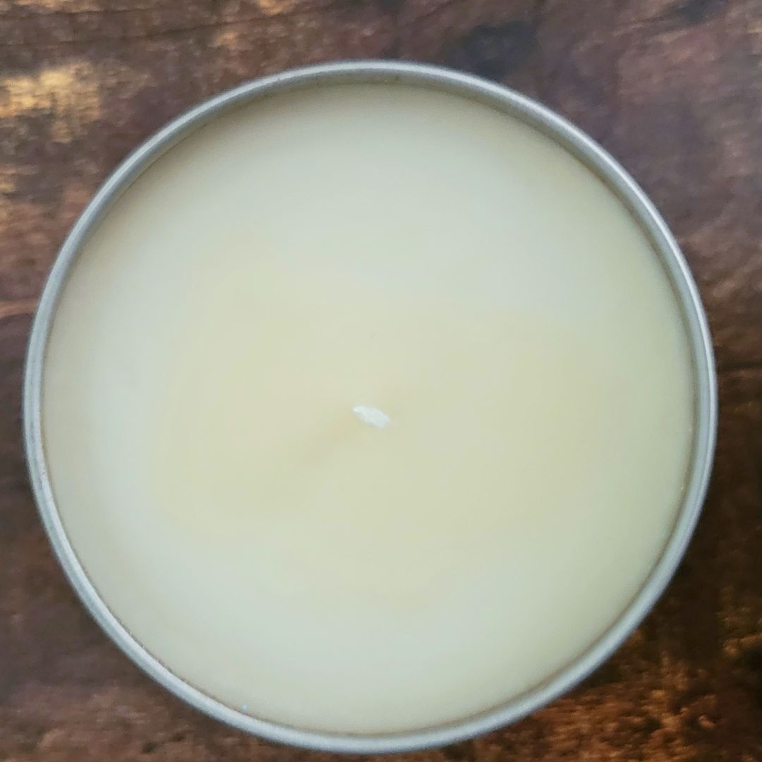 Metallic tin with a white cream-like substance on a wooden surface