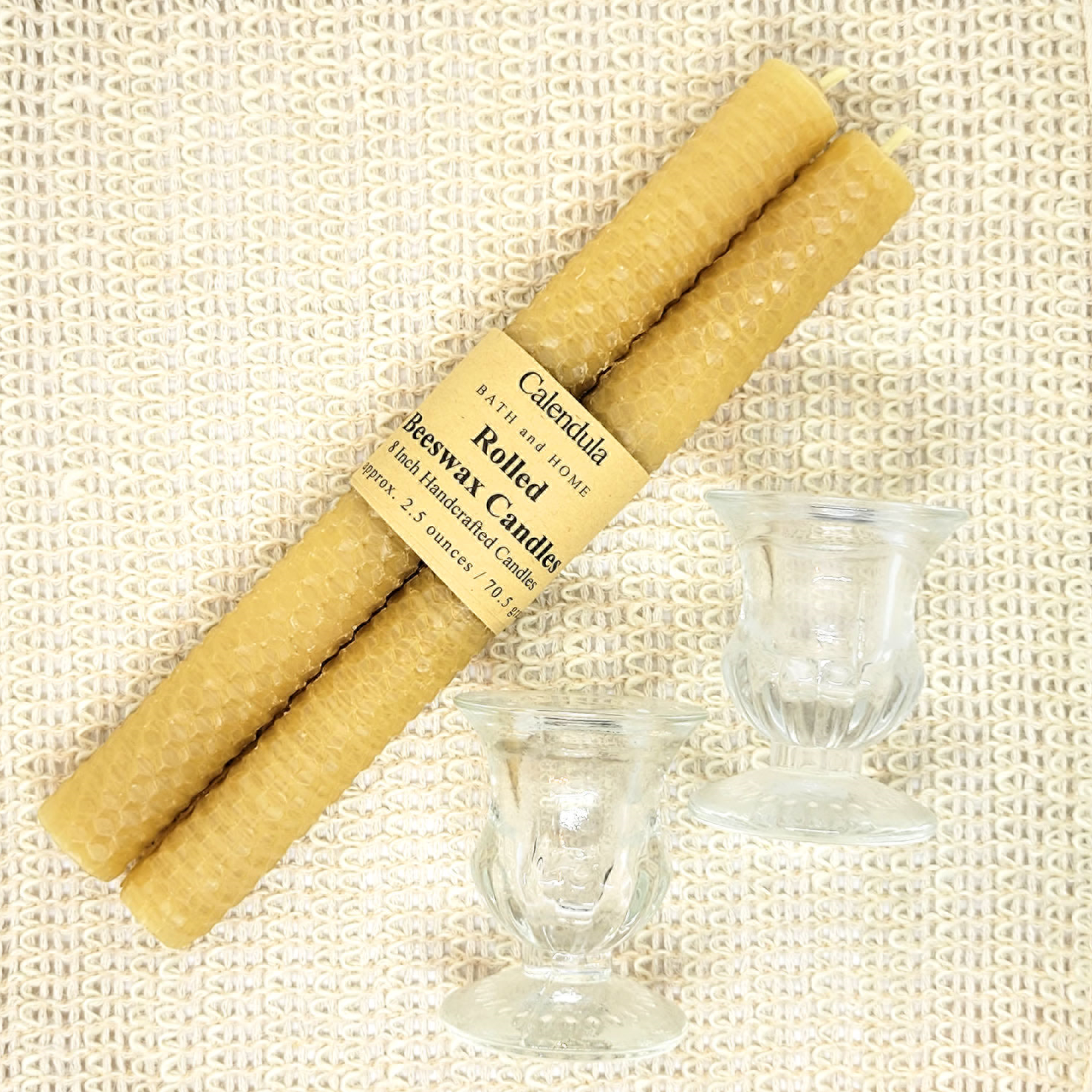 pair of rolled beeswax candles and glass holder